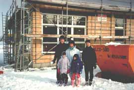 Chefin mit Kindern vorm Rohbau